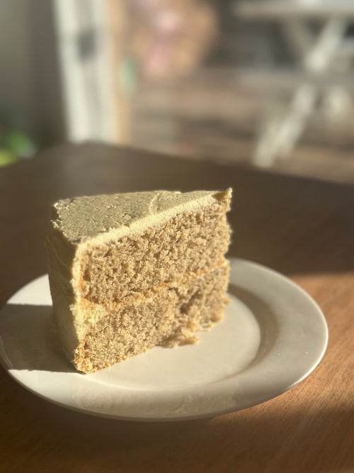 A freshly baked, slice of premium gluten-free vanilla bean cake made with unspent vanilla bean powder and no added sugar, presented on a white plate.